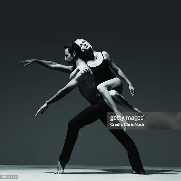 female dancer holding onto the back of a male dancer - effortless experience stock pictures, royalty-free photos & images