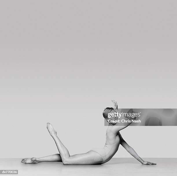 portrait of a female dancer lying down with her hand on her head - hand on head foto e immagini stock