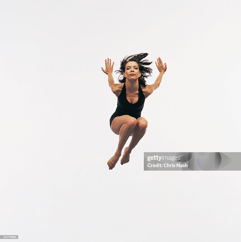 Hispanic Female Dancer Jumping in Mid Air