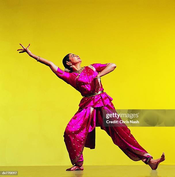 indian dancer with one arm raised - legs spread stock-fotos und bilder