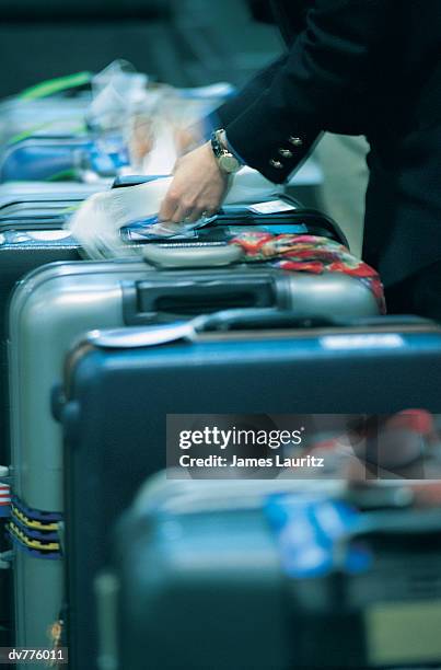 close up of adult attaching luggage tag's to baggage at an airport - tag ストックフォトと画像