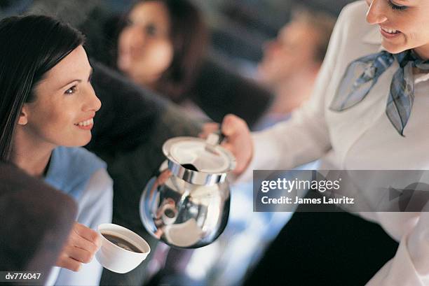 female passenger being served coffee by an air stewardess - travel14 fotografías e imágenes de stock