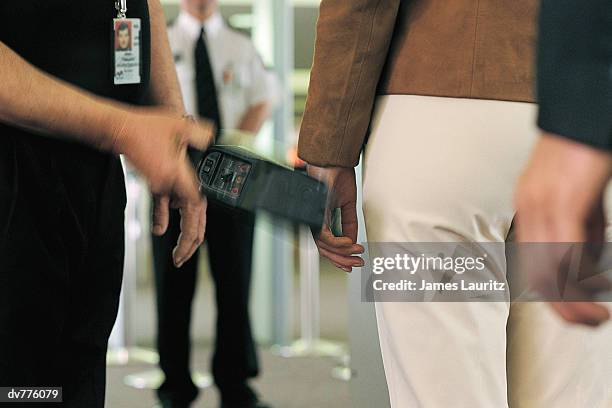close up of people being examined by a metal detector at an airport - security scanner stock pictures, royalty-free photos & images