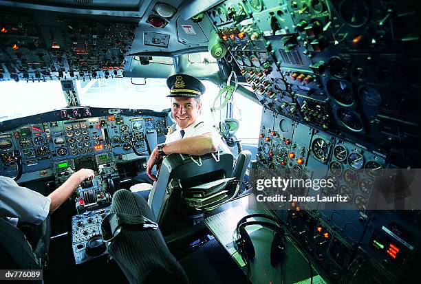 portrait of a pilot sitting at the controls of a commercial aeroplane - cockpit 個照片及圖片檔