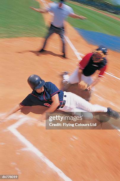 baseball player safe at home base - base sports equipment stock-fotos und bilder