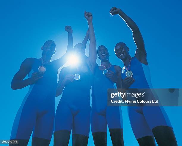 four athletes celebrating their success - médaillé photos et images de collection