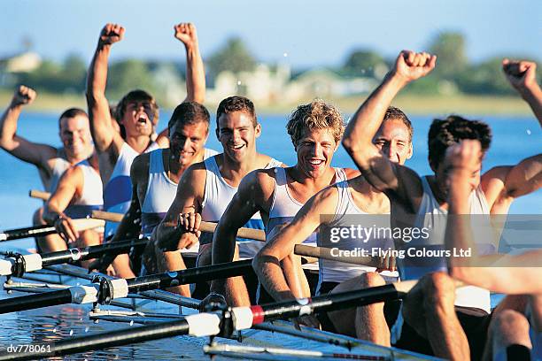 men celebrating success from sculling on river - remo de punta fotografías e imágenes de stock