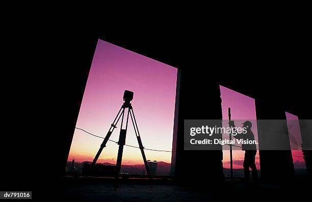 surveryor on a construction site at twilight - geodesy stock pictures, royalty-free photos & images