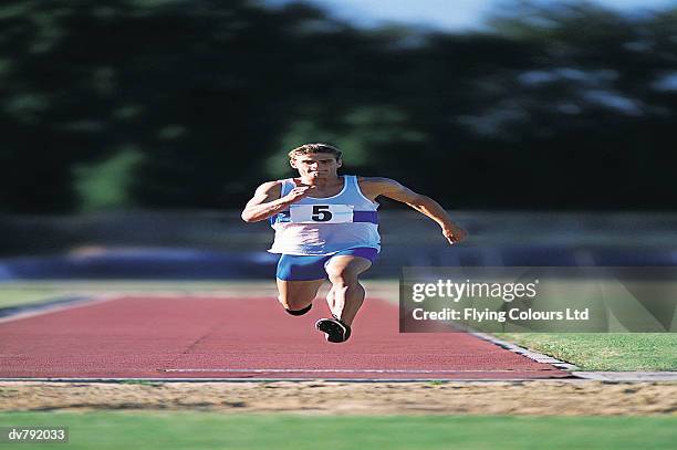 athlete practicing the long jump - men's field event stockfoto's en -beelden