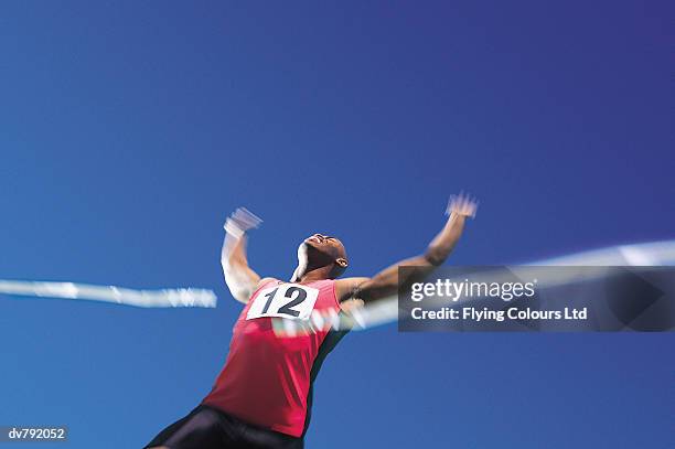 winning athlete at the finishing line - ltd stock pictures, royalty-free photos & images