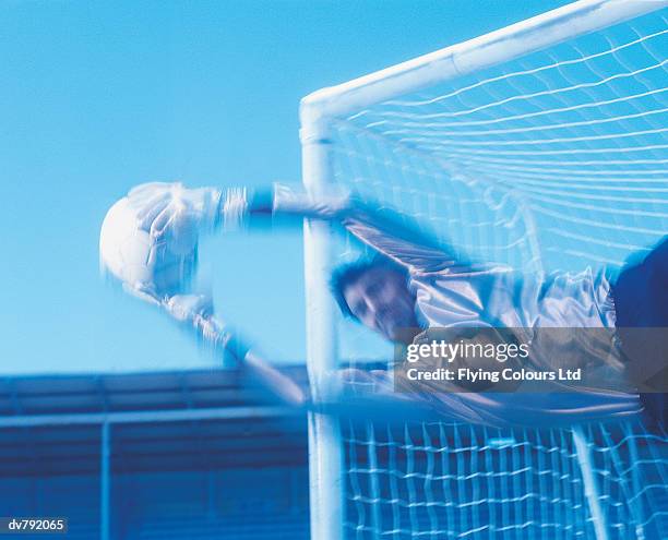 diving goalkeeper making a save - making a save sports stock-fotos und bilder