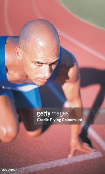 track athlete crouching at the start of a race - ltd stock pictures, royalty-free photos & images