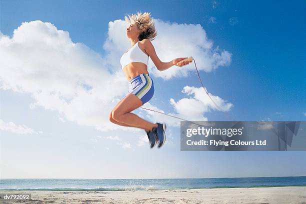 woman jumping rope on the beach - ltd stock pictures, royalty-free photos & images