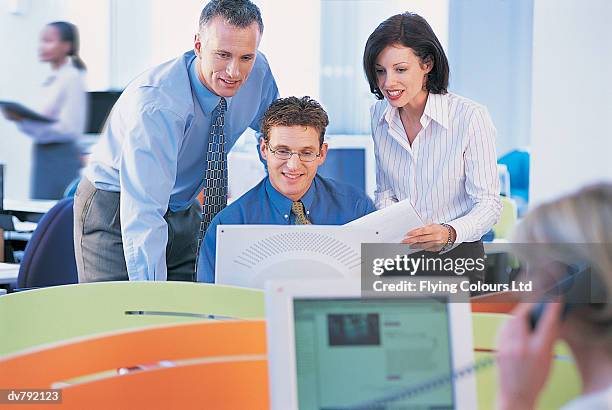 three business executives looking down at a computer - ltd stock pictures, royalty-free photos & images