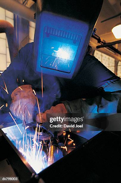 welder wearing protective clothing with sparks reflected in visor - sparks bildbanksfoton och bilder