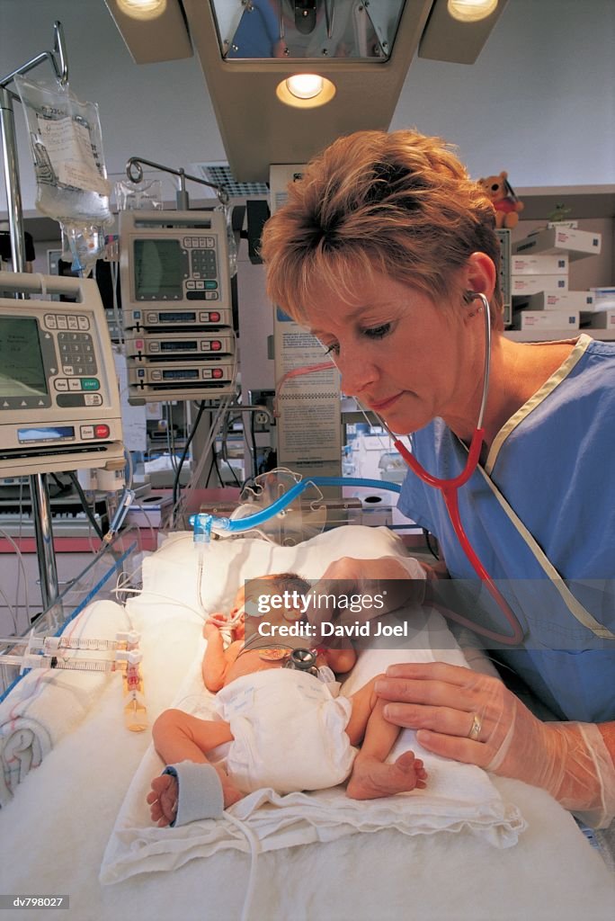 Nurse checking premature baby in intensive care