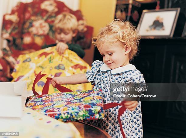 two children opening their presents at christmas - opening celebration of gregory colberts ashes and snow exhibition arrivals stockfoto's en -beelden