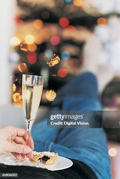 close-up of a man with holding a mince pie and some champage - christmas mince pies stock pictures, royalty-free photos & images