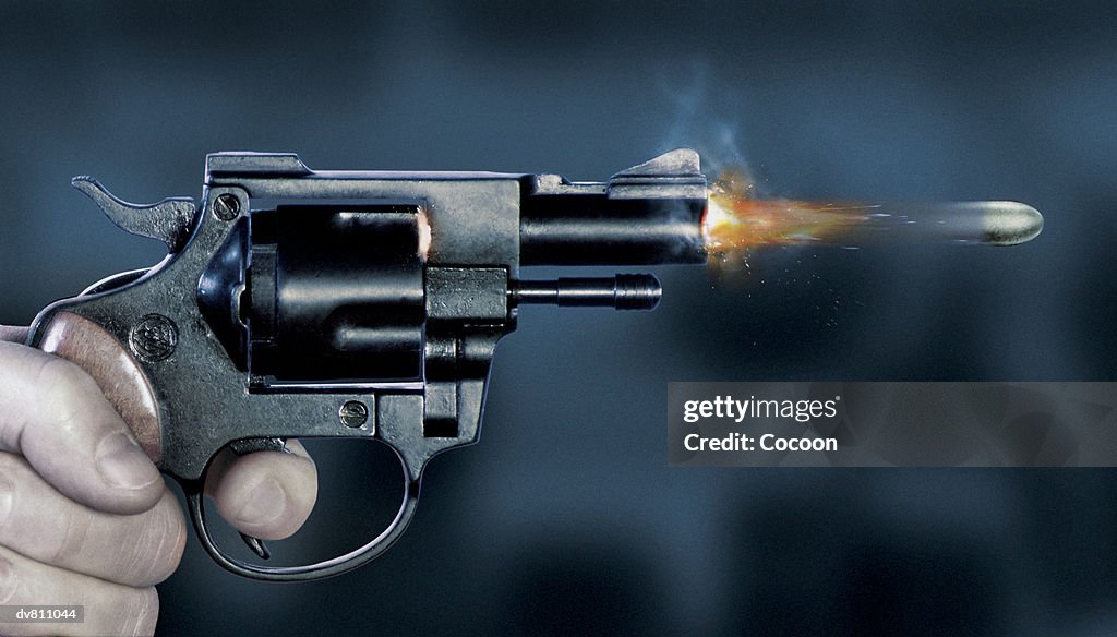 Close Up of a Bullet Coming Out of a Gun