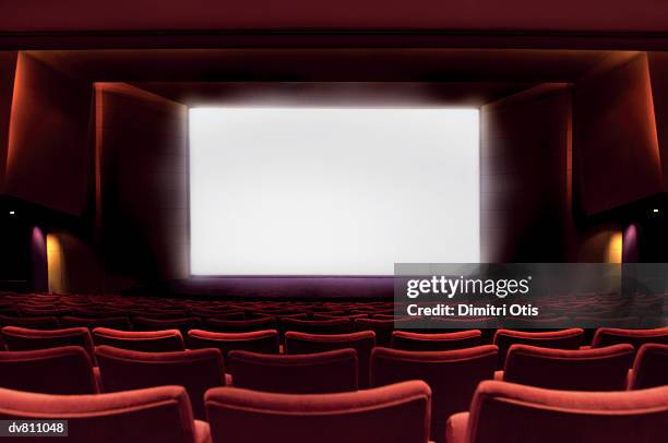 illuminated projection screen in an empty cinema - projection screen stockfoto's en -beelden