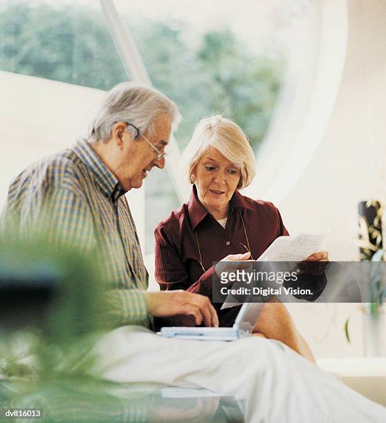 mature couple working at home - silver surfer stock pictures, royalty-free photos & images