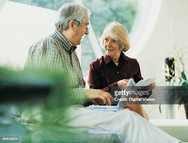 mature couple working at home - idoso na internet - fotografias e filmes do acervo
