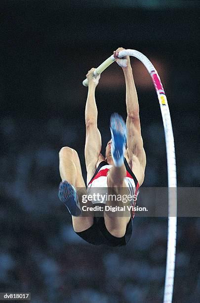 man in a pole vault competition - pole vault stock-fotos und bilder