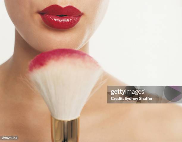 woman blowing blush off a make-up brush - pincel de blush imagens e fotografias de stock