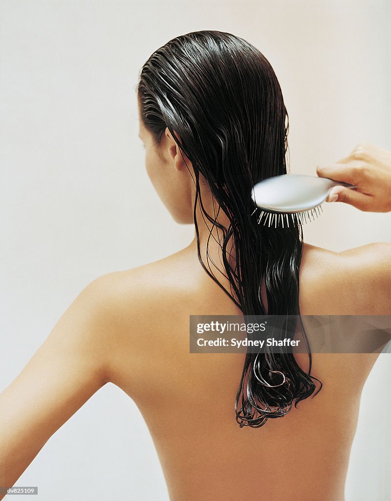 Rear View of Young Woman Brushing Her Hair