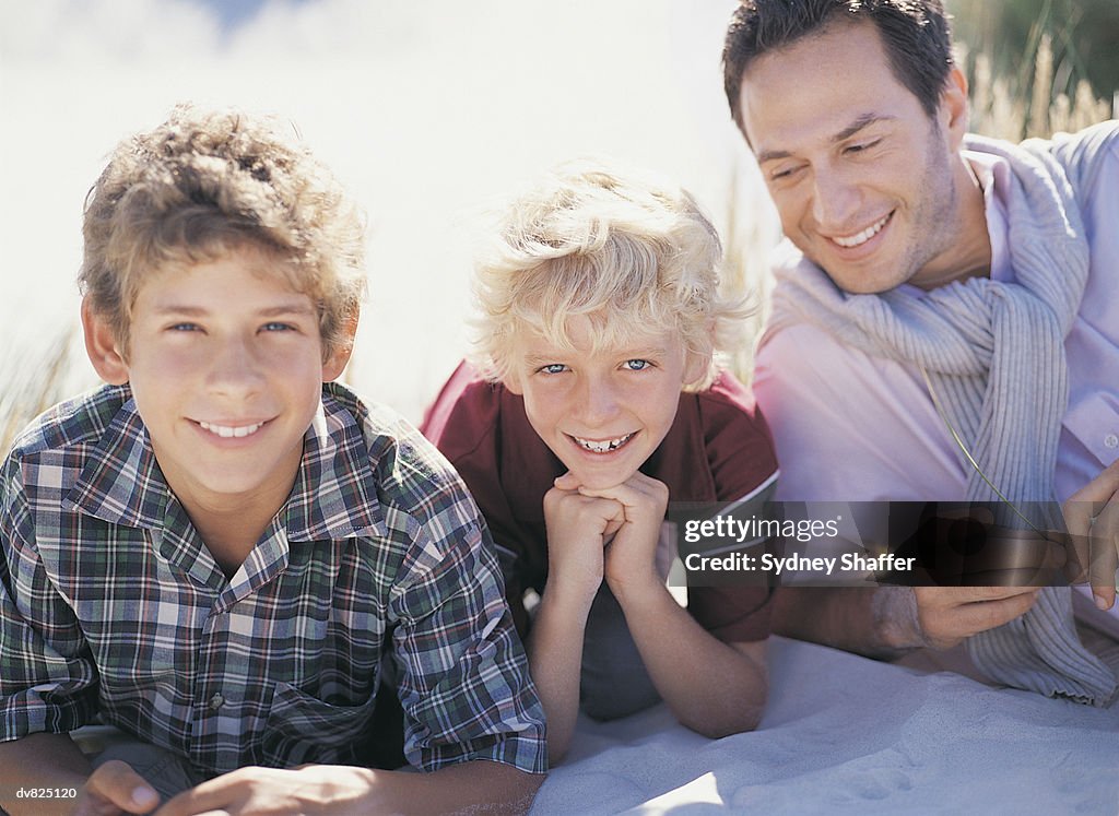 Portrait of a Father and His Two Sons Lying on the Sand in the Dunes