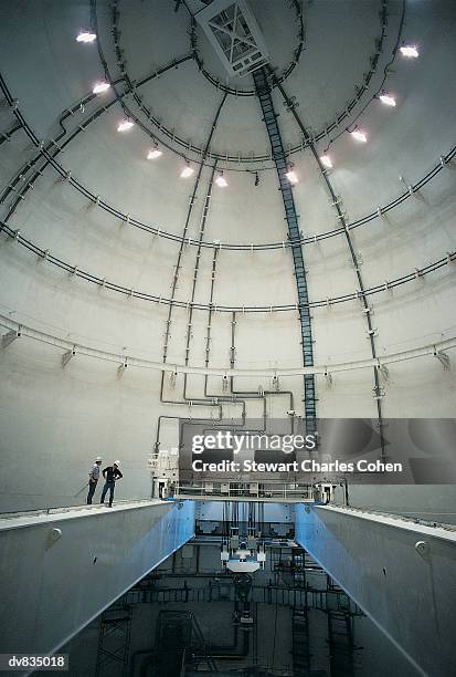 two men in hard hats inspecting the dome of a nuclear power station - stewart stock-fotos und bilder