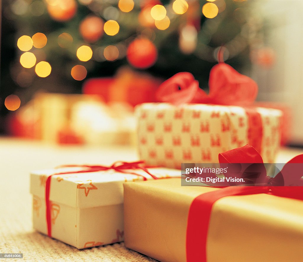 Close-Up of presents with Christmas Tree in background