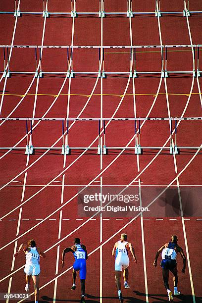 athletes starting to run hurdles - running track stock-fotos und bilder