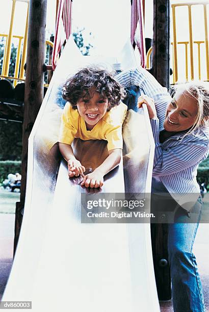 girl on a slide with her mother beside her - digital devices beside each other bildbanksfoton och bilder