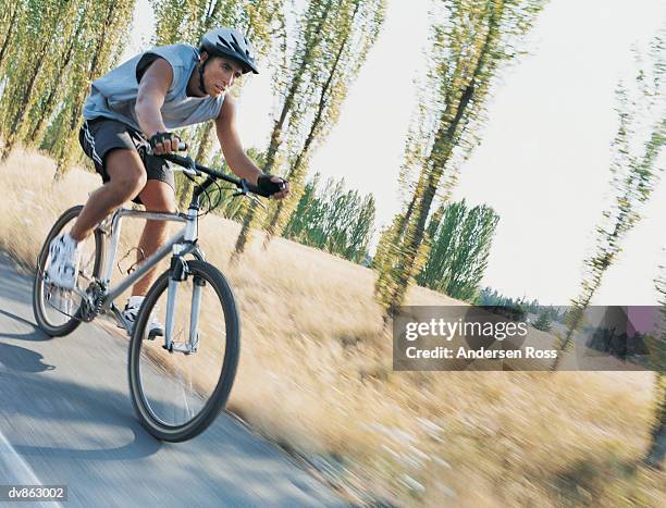 man riding a bike through the countryside - andersen stock pictures, royalty-free photos & images