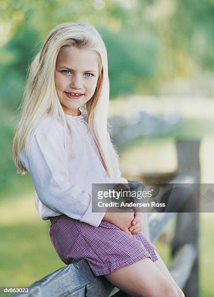 portrait of a girl sitting on a fence - andersen ross stock pictures, royalty-free photos & images