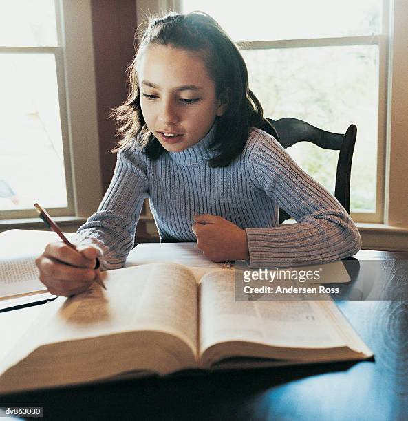 girl sitting studying, reading a book - ross stockfoto's en -beelden
