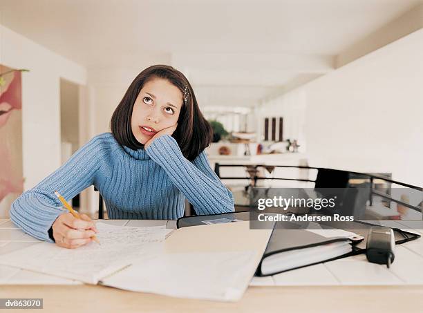 female teenager looking upwards whilst doing her homework - ross stock pictures, royalty-free photos & images