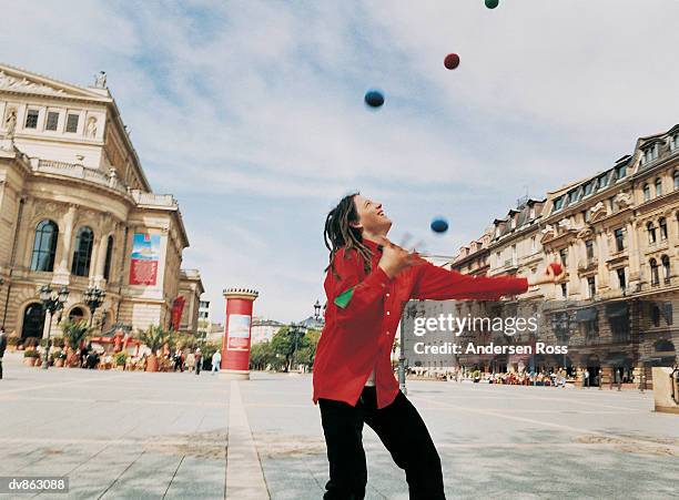 busker with dreadlocks juggling in a town square - andersen stock pictures, royalty-free photos & images