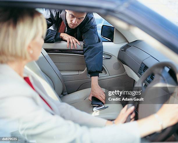 businesswoman in car as robber steals her purse through the car window - stranger danger stock pictures, royalty-free photos & images