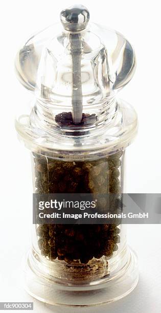 black peppercorns in a pepper mill - pepper mill - fotografias e filmes do acervo
