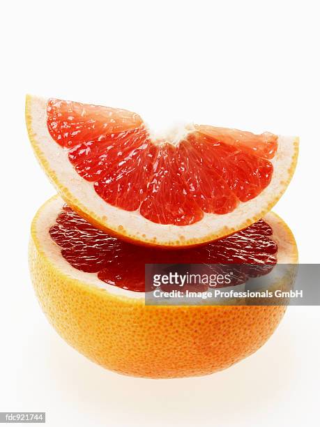 wedge of pink grapefruit on grapefruit half - pink grapefruit stock pictures, royalty-free photos & images