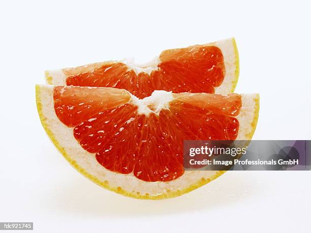 two wedges of pink grapefruit - pink grapefruit stock pictures, royalty-free photos & images