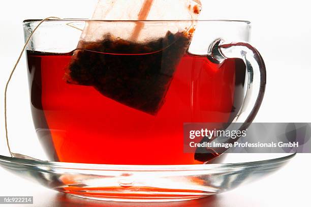 hibiscus tea in glass cup with tea bag - herbal tea bag stock pictures, royalty-free photos & images