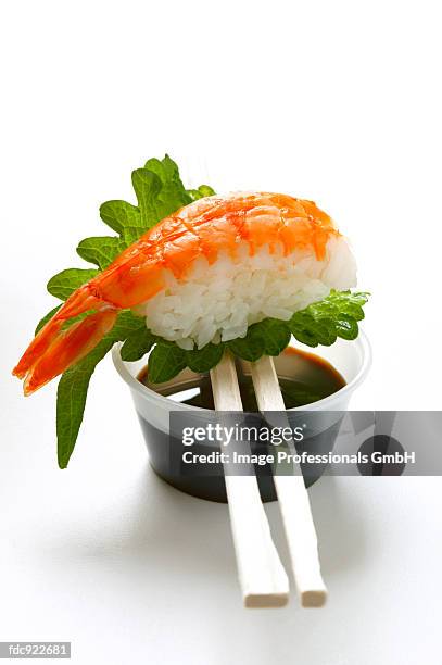 nigiri sushi with shrimp and shiso leaf on soy sauce - sushi rice stock pictures, royalty-free photos & images