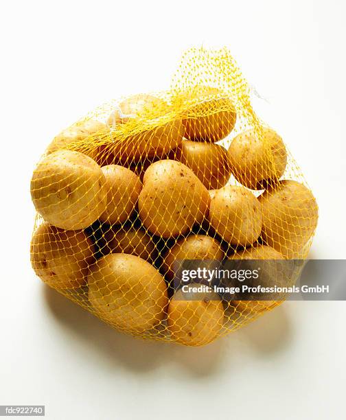 yukon gold potatoes in net - yukon gold stock pictures, royalty-free photos & images