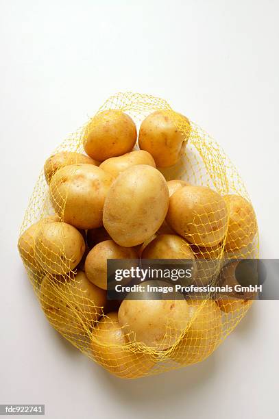 yukon gold potatoes in net - yukon gold stock pictures, royalty-free photos & images