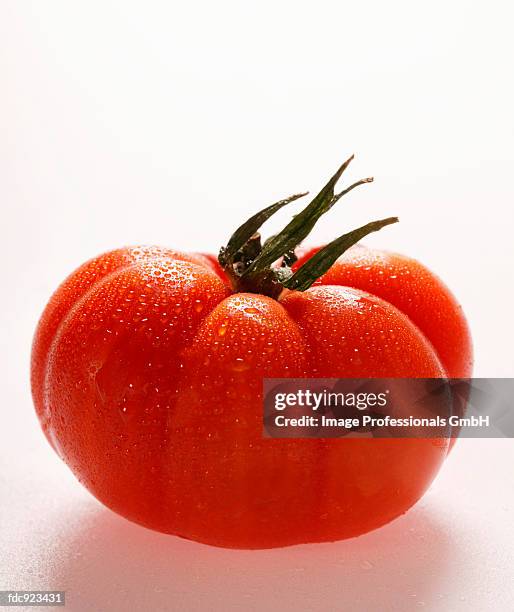 beefsteak tomato with drops of water - beefsteak tomato stock pictures, royalty-free photos & images