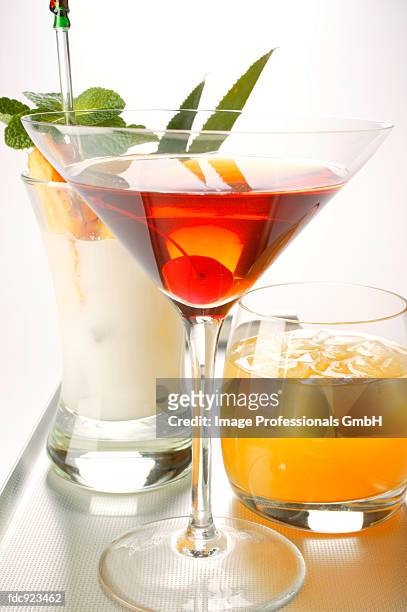three different cocktails on tray - rosso stock-fotos und bilder