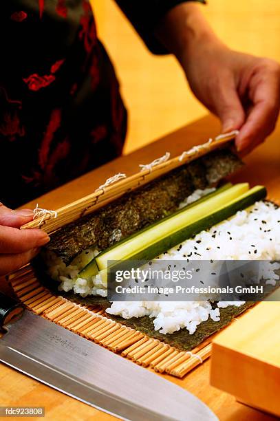 preparing rolled maki-sushi - sushi rice stock pictures, royalty-free photos & images